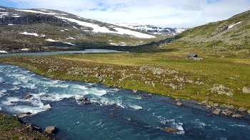 aerial photography of winding river between snowy mountains