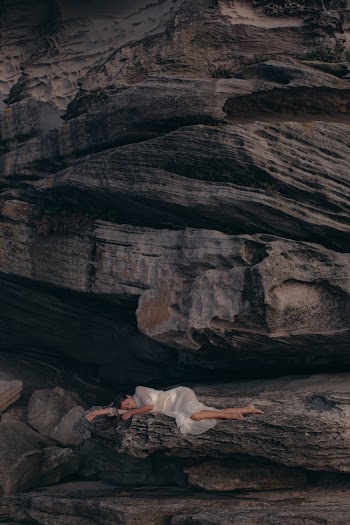 Aerial Photography of Woman Lying on Rock Mountain
