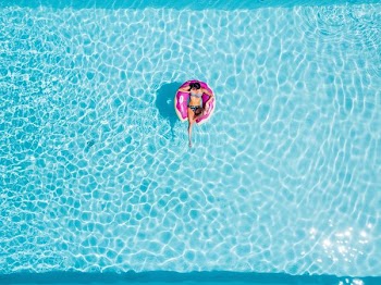 aerial photography of woman on pink swimming floats