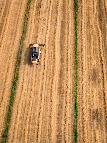 aerial photography of yellow cultivator on brown field