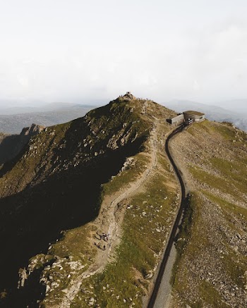 Aerial Shot Of A Road Leading Up To A Builgind On Top Of A Hill