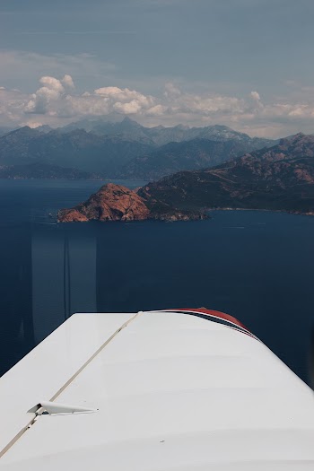 Aerial View From An Aircraft Of Mountains Surrounded By A Large Body Of Water