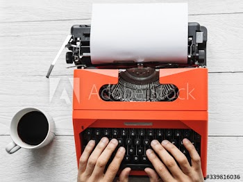 Aerial view of a man typing on a retro typewriter blank paper