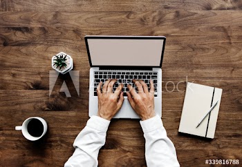Aerial view of a man using computer laptop on wooden table