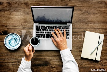 Aerial view of a man using computer laptop on wooden table