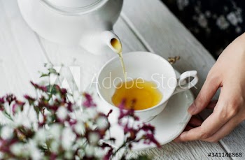 Aerial view of a woman pouring a hot tea drink