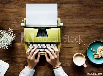 Aerial view of a woman typing on a retro typewriter blank paper