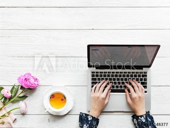 Aerial view of a woman using computer laptop working and hot tea drink