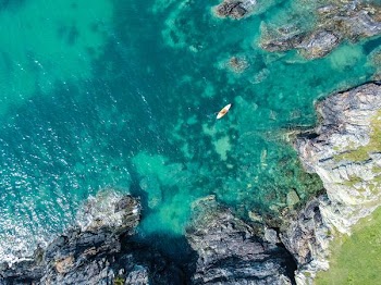 aerial view of boat on sea beside rock formation at daytime