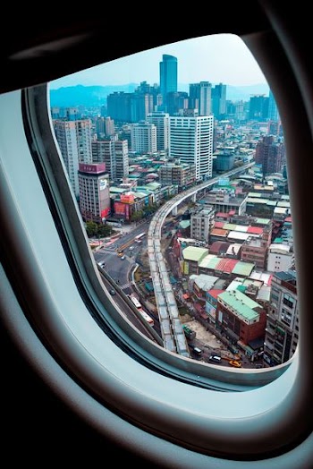 Aerial View of City Through Airplane Window