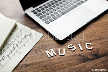 Aerial view of computer laptop on wooden table and letters forming the word music