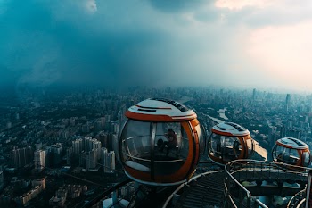 Aerial View of Red-and-white Enclosed Rides Overlooking City