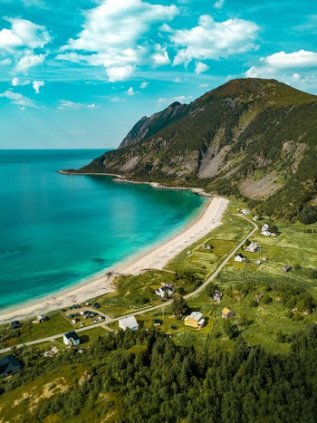 Aerial View of Shore Beside Green Mountains