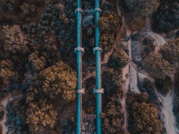 aerial view of two blue water pipes near green leaved trees