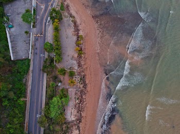 Aerial View of Waves Moving Towards Shore near Road