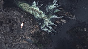 Aerial View of Woman Lying on Rock