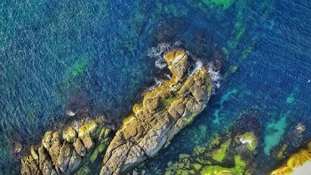 aerial view photography of rock formations surrounded by ocean during daytime