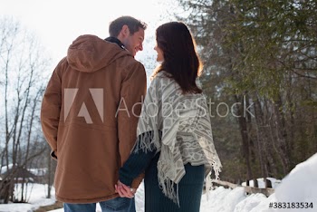 Affectionate couple holding hands on snowy footpath