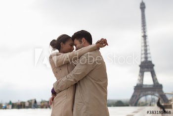 Affectionate couple hugging in front of Eiffel Tower, Paris, France