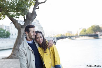 Affectionate couple walking along Seine River, Paris, France