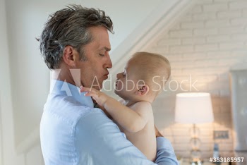 Affectionate father holding baby son