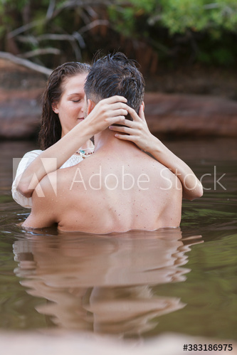 Affectionate sensual couple kissing in lake