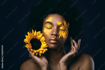 African woman with a sunflower and creative makeup on her face