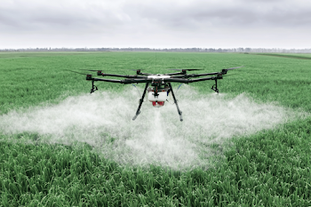 Agricultural Drone Spraying Over Lush Green Fields