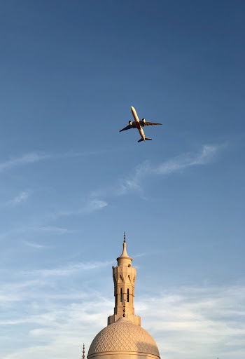 Airplane Flying Above Building