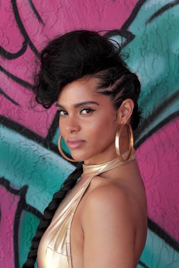 Alicia Keys standing near wall with graffiti art
