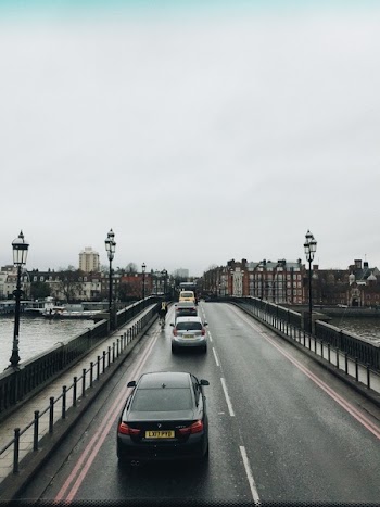 All Vehicles Passing on Left Lane of Road While Right Lane Is Empty Under Gray Sky