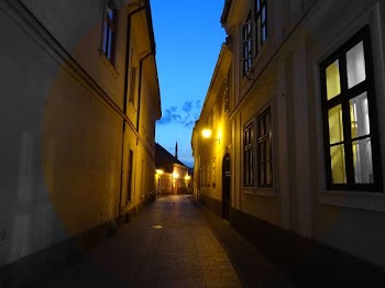 Alley With Beige Painted Buildings Under Blue Sky