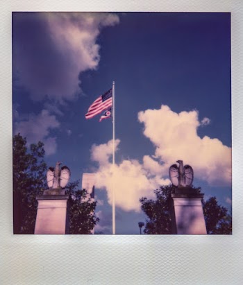 American Flag Flying on Pole Between Two Eagle Statues