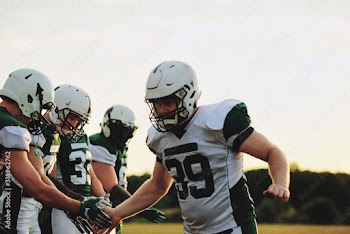 American football team celebrating with low fives after a game