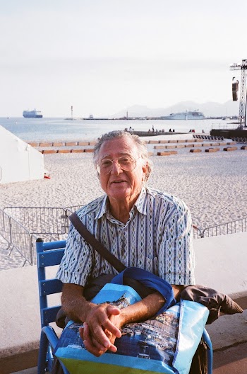 An elderly man sitting on armchair near the ocean