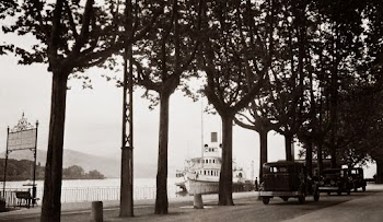An Old Black And White Photo Of Cars In A Street By The River With A Boat Anchored By The Docks