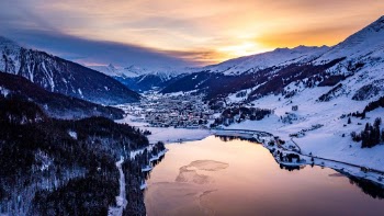An unusual view on my hometown, Davos, Switzerland. It’s amazingly settled in between beautiful mountains at 1’560 a.s.l. The lake in front reflects the amazing colours of the setting sun. You can even see the train of the Rhätische Bahn (RhB) at the bottom left hand side.