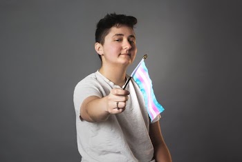 Androgynous Person Holds Trans Pride Flag