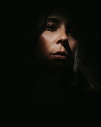 Anonymous enigmatic woman standing in darkness · Free Stock Photo