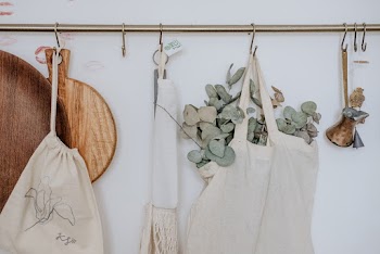 Aprons, Chopping Board and Bag Hanged on White Painted Wall