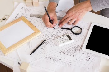 Architect drawing a plan on paper mockup Free Photo