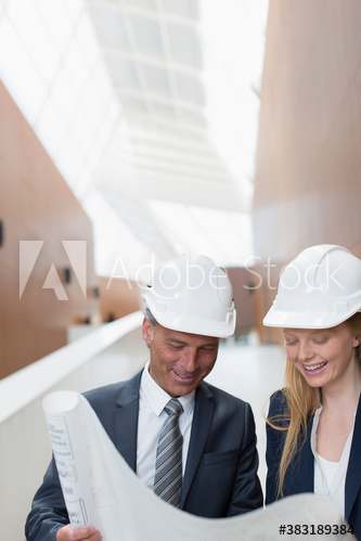 Architects in hard hats looking at blueprints