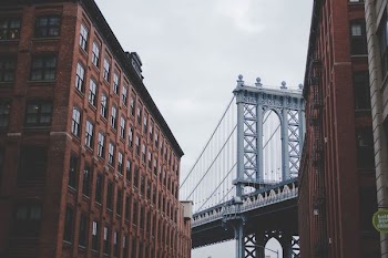 architectural photography of gray bridge and brown building