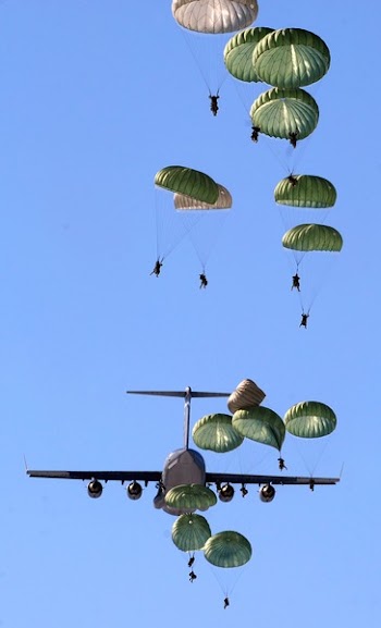 Army Paratroopers Practicing Parachute Drop from a Military Air Plane during Daytime