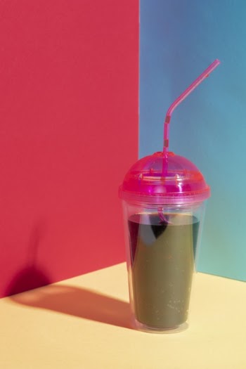 Arrangement with juice cup on yellow table Free Photo