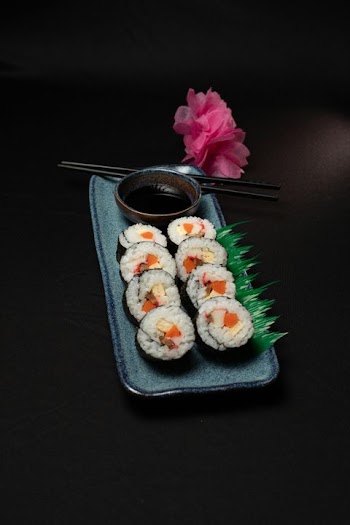 Artistic Sushi Presentation with Soy Sauce and Edible Garnish
