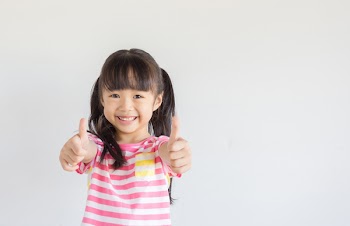asian child show her thumbs to cheer up with happily