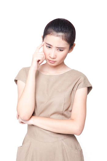 Asian woman looking down and thinking