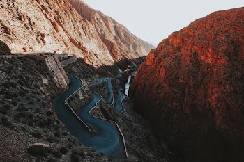 asphalt road beside mountains