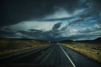 asphalt road near field under white clouds